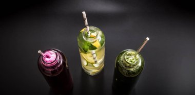 Siyah arka planda doğal üç smoothies içecekler.