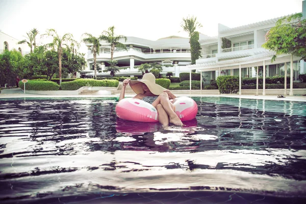 Летний отдых у бассейна. Женщина на надувном пончике — стоковое фото