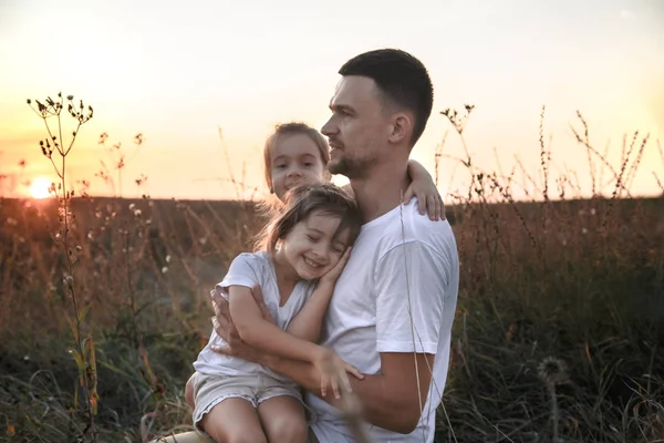 Papá y sus hijas en el campo al atardecer  . —  Fotos de Stock