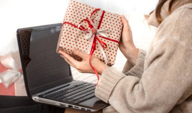 Bilgisayar ve Noel hediyeleri ile güzel kadın.