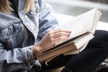 Bir kafede oturan ve kitap okuyan genç kız
