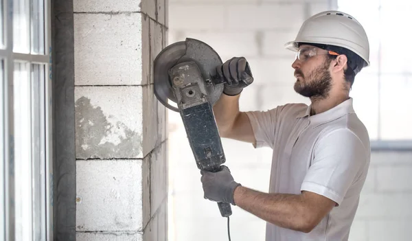 The industrial Builder works with a professional angle grinder t — Stock Photo, Image