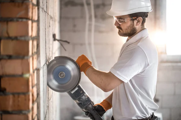 O construtor industrial trabalha com um moedor de ângulo profissional t — Fotografia de Stock