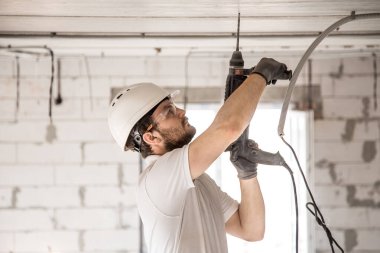 Tamirci, tesis için matkap kullanıyor. Profesyonel işçi. 