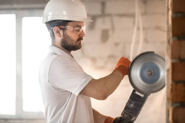 The industrial Builder works with a professional angle grinder t — Stock Photo, Image