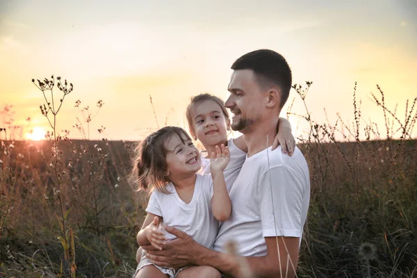 Papá y sus hijas en el campo al atardecer  . —  Fotos de Stock