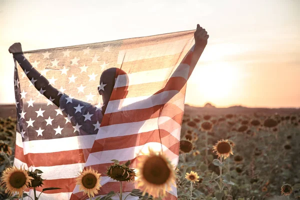 Ein Mann hält eine amerikanische Flagge bei Sonnenuntergang. — Stockfoto