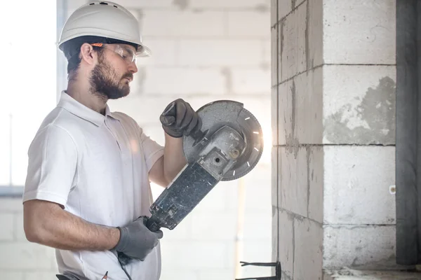 The industrial Builder works with a professional angle grinder t — Stock Photo, Image