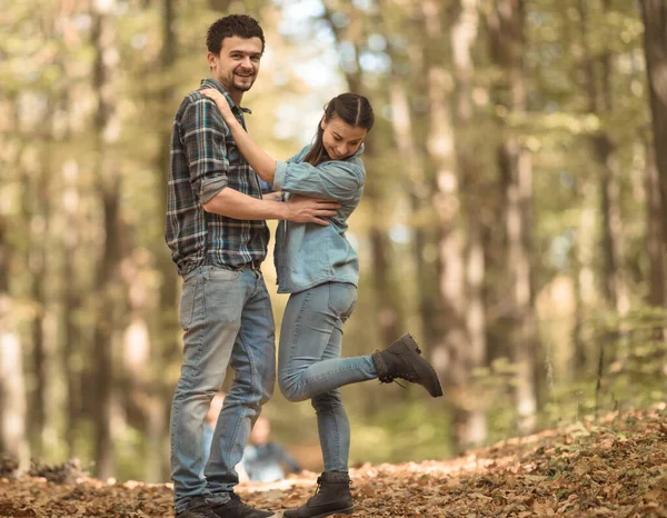 Una joven pareja caminando en el bosque de otoño . —  Fotos de Stock