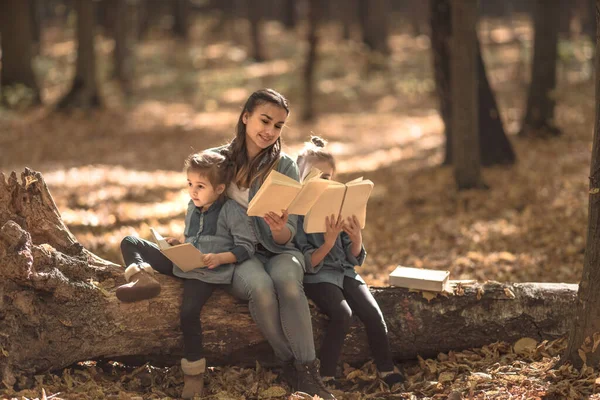 Anya könyvet olvas a gyerekeknek az erdőben.. — Stock Fotó
