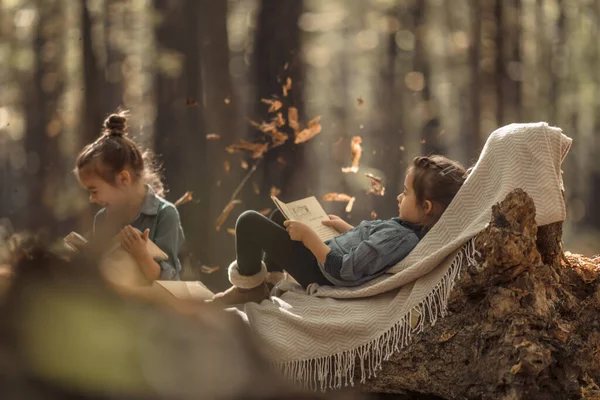Zwei kleine Mädchen lesen Bücher im Wald. — Stockfoto