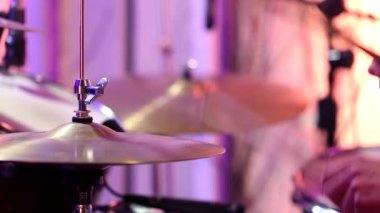 Stüdyoda davulcu var. Metal skorlarla davul çalıyor. Statik video kaydı. Kapat..