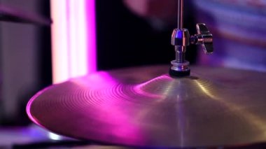 Stüdyoda davulcu var. Metal skorlarla davul çalıyor. Statik video kaydı. Kapat..