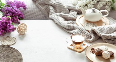 Çay ve çiçek açan leylakla sıcak bahar kompozisyonu. Üst manzara, düz uzanma