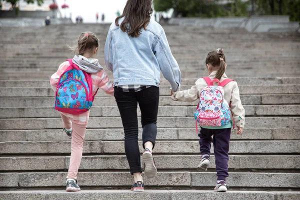 Rodzic Uczeń Szkoły Podstawowej Idą Parze Mama Dwóch Dziewczyn Plecakiem — Zdjęcie stockowe