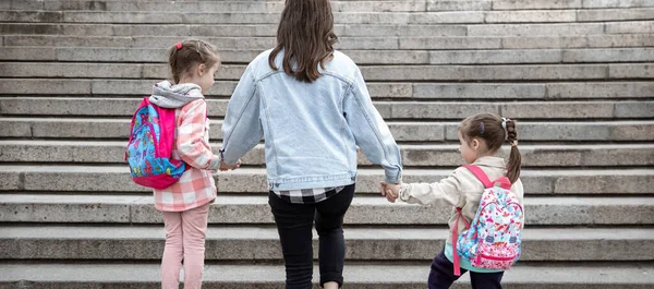 Lkokulun Ebeveynleri Öğrencileri Ele Gider Sırt Çantalı Iki Kızın Annesi — Stok fotoğraf