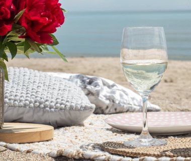 Deniz kenarında çiçekler ve bir bardak şampanyayla piknik. Tatil kavramı..