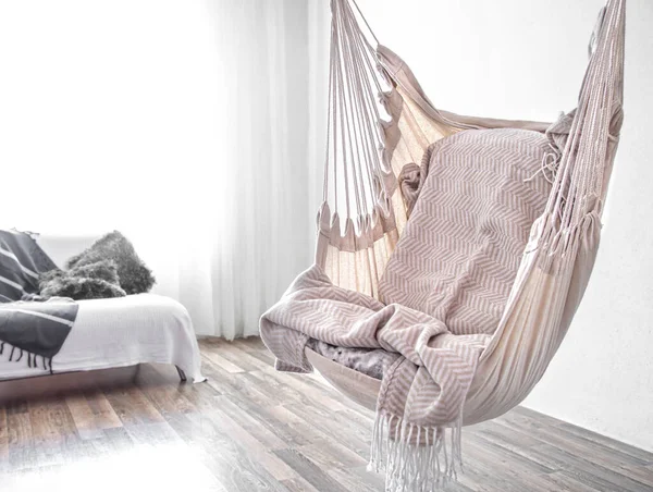 Hammock chair in boho style. Cozy interior. The concept of rest and home comfort. Space for text.