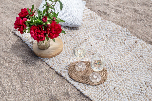 Picnic by the sea with flowers and a glass of champagne . The concept of a holiday.