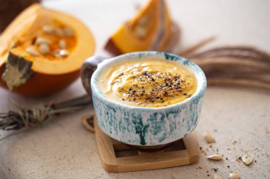 Güzel bir seramik tabakta balkabağı çorbası ile nefis bir kompozisyon. Yukarıdan manzara. Mevsimlik yiyecekler.