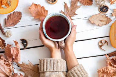 Yapraklı sonbahar kompozisyonu ve beyaz arka planda bir fincan çay. Sonbahar konsepti.