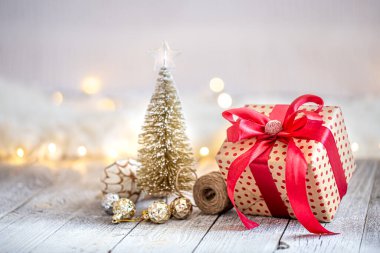 Noel oyuncakları ve kırmızı kurdeleli hediye kutusu olan güzel bir Noel arkaplanı. Selamlama ve yeni yıl kutlamaları konsepti.