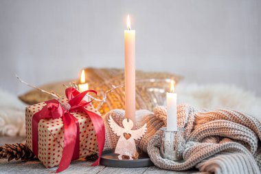 Ahşap bir masada mum ve bir hediyeyle huzurlu bir hayat. Şenlik konsepti.
