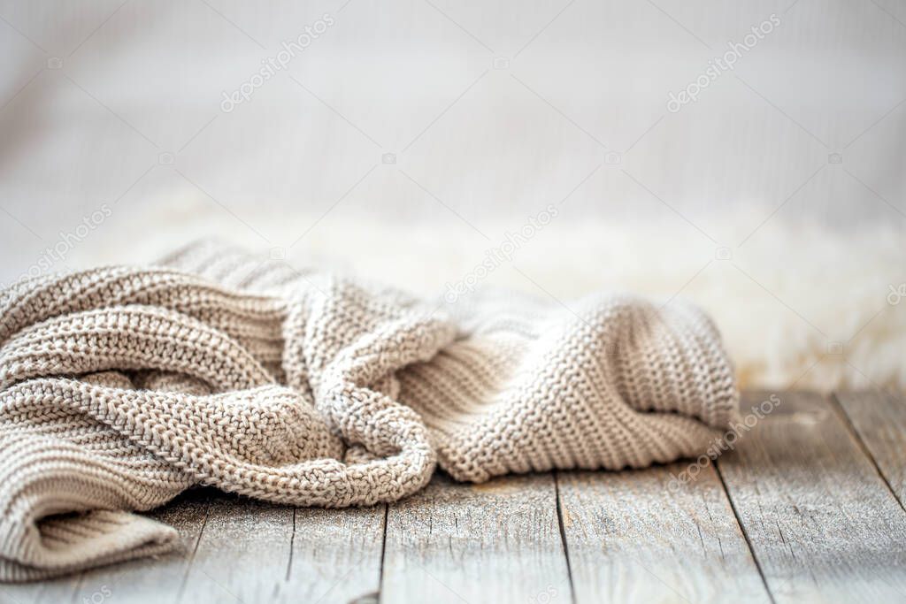 Background with a cozy knitted sweater, space for text. Minimalism, knitted texture, order, comfort, macro. Banner with copy space for text.