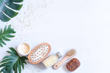 Beyaz arka planda vücut bakım ürünleri ve doğal yapraklarla spa kompozisyonu. Spa-kozmetik ürünleri kavramı.