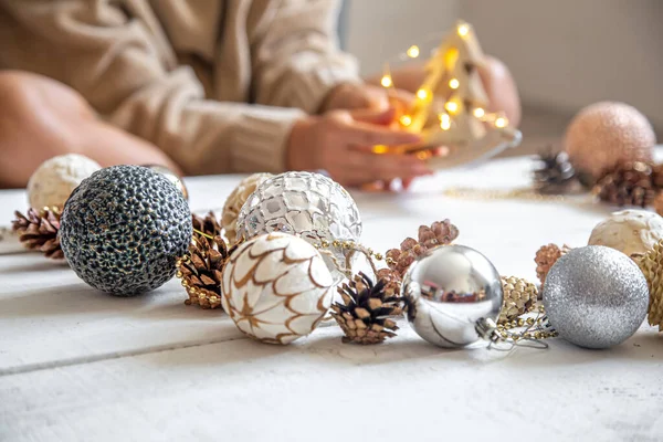 クリスマスボールと女性の手で構成 女性は光るライトの木製のおもちゃを持っています お正月のコンセプト — ストック写真