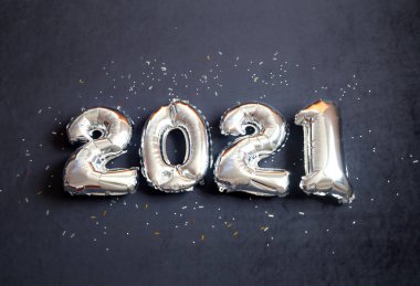 Gümüş folyo balonları siyah arka planda 2021 numara yaptı. Tatil partisi dekorasyonu. Yeni yılınız kutlu olsun, tebrikler..