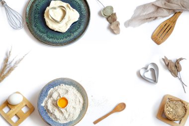 Beyaz arka planda pişirme malzemeleri ve mutfak aksesuarları olan kompozisyon.