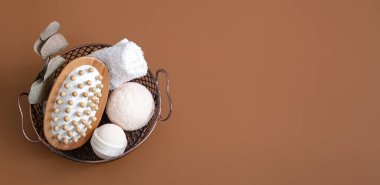 Masaj fırçası, banyo bombaları ve havlu kahverengi arka plan fotokopi alanı ve üst görünüm sepetinde.