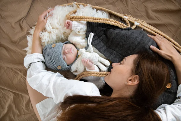 Молода Щаслива Мати Спляча Дитина Плетеній Колисці Теплому Язаному Капелюсі — стокове фото