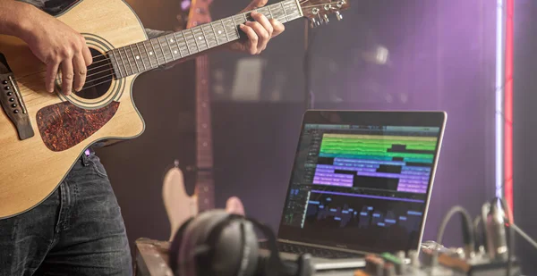 연주자는 스튜디오에서 어쿠스틱 기타를 스튜디오 배경에 사운드 트랙이 노트북 모니터 — 스톡 사진