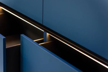 Paralel çekmeceler ve doğrusal LED kanalı derinlik ve gevrek geometri ekler. Sırtında minimalist bir titreşim olan mat mavisi çağdaş bir mutfak..