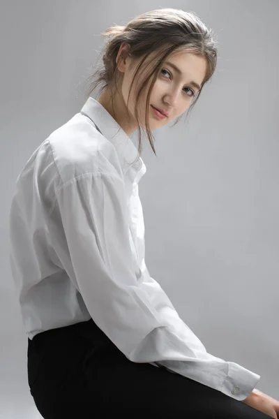 Elegante Chica Morena Camisa Blanca Sentada Mirando Cámara Aislada Gris Imagen De Stock