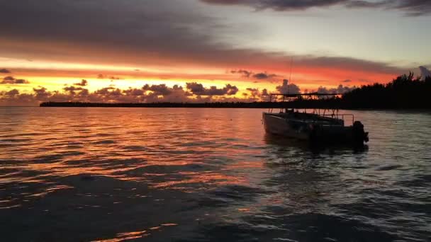 El barco se mece en las olas en los rayos del atardecer — Vídeos de Stock