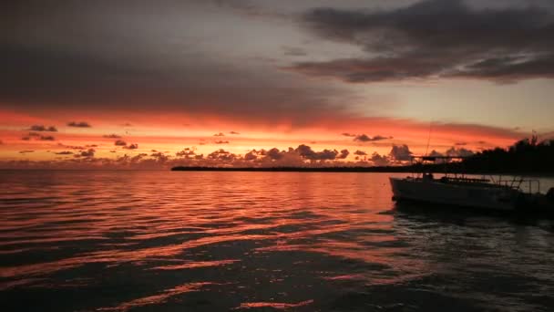 ボートは、夕日の光線で波の岩します。 — ストック動画