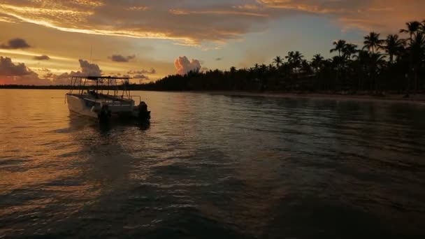 El barco se mece en las olas en los rayos del atardecer — Vídeos de Stock