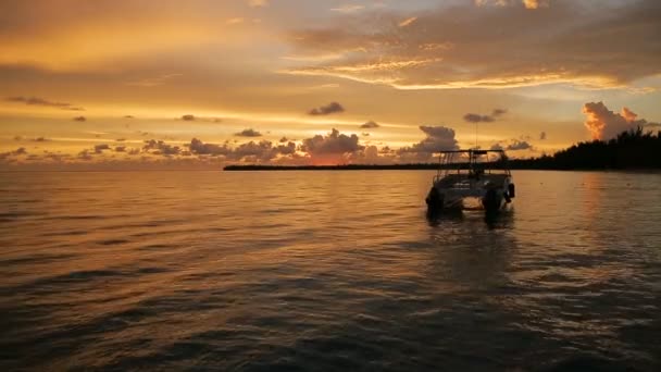 El barco se mece en las olas en los rayos del atardecer — Vídeos de Stock