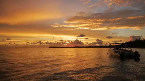 O barco balança nas ondas nos raios do pôr-do-sol — Vídeo de Stock