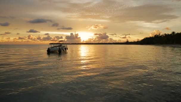 El barco se mece en las olas en los rayos del atardecer — Vídeos de Stock