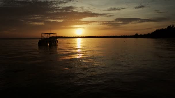 El barco se mece en las olas en los rayos del atardecer — Vídeos de Stock