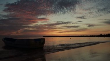 Tropikal ada plajı ve palmiye ağaçları üzerinde gün doğumu