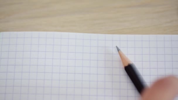 Primo piano di una mano che scrive una matita in un quaderno — Video Stock