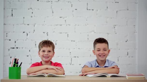 Uczniowie śmiech na biurku w klasie — Wideo stockowe