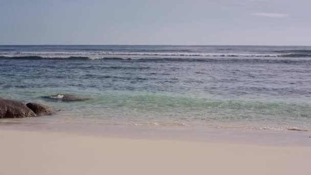 Океан вымывает большие камни на берегу Сейшельских островов — стоковое видео