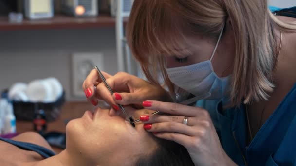 Extensión de pestañas en el ojo femenino . — Vídeos de Stock