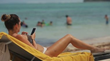 Kız bir cep telefonu ile sahilde